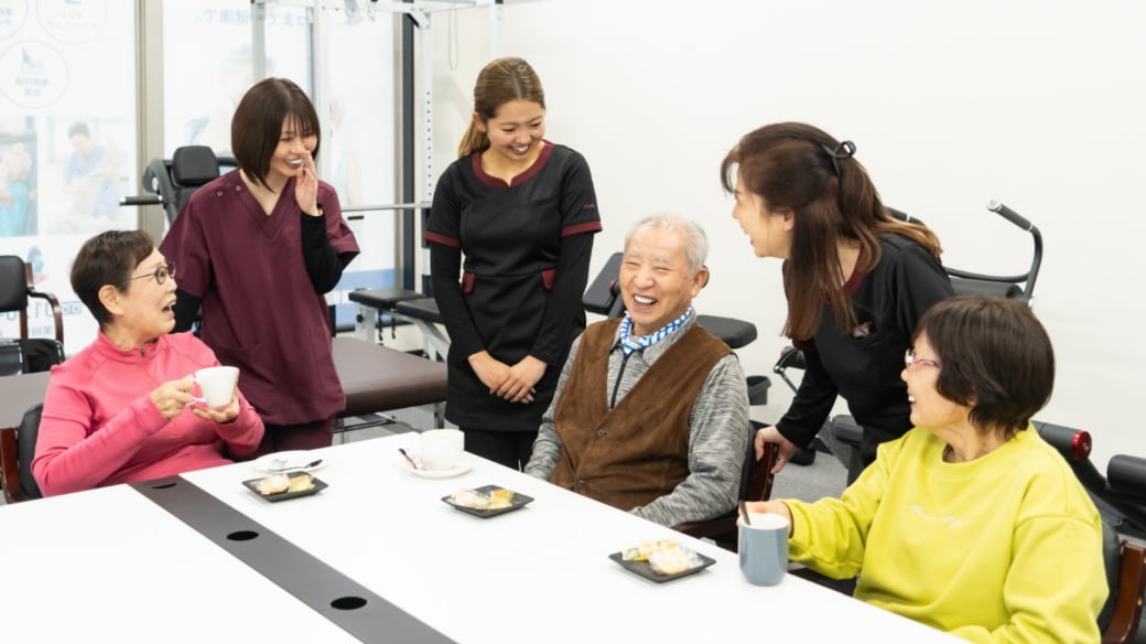 スタッフや他の利用者と共に、和やかにおやつを食べるご利用者様